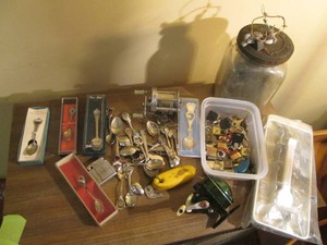 Collection of vintage souvenir spoons, padlocks, fishing reels and other items shown