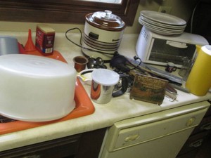 Toaster oven, Crock pot, misc silver plated serving utensils and other kitchen supplies shown