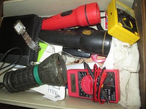 Junk drawer content to include multi-meters, flashlights, day planner, watch, Leatherman style tool and more