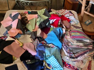 Lot of assorted fabric quilt squares including various patterns, colors, and textures