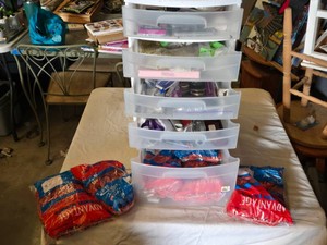 Clear plastic storage drawers filled with rubber bands, tools, and crafting supplies, scissors, lighters, necklace findings and more