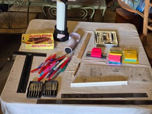 Lot of office supplies and craft tools including rulers, paper cutters, scalpels, and Post-it notes