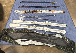 2 pairs of skis, 3 pairs of ski poles, and Dakine floral ski bag