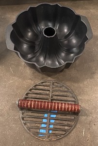 Fluted tube cake pan and a cast iron grill press with a wooden handle