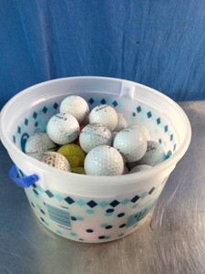 Bucket of mixed, used golf balls including brands like Callaway, Nike, and Pinnacle