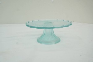 aqua green pedestal cake stand with scalloped rim and starburst pattern
