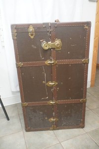 The Oshkosh Trunk Co. large travelers trunk opens to a hanging clothes section and 5 drawers in very good condition 23 x26 x 42