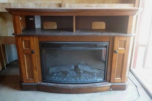 electric fireplace in nice wood cabinet with storage on the sides and shelf above