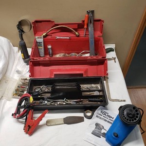 Toolbox with Assorted Tools and Accessories like jumper cable parts, a wrench, a screwdriver, lubricant, and various small hardware parts