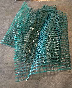 Green poles and plastic fencing