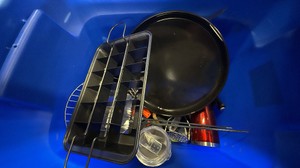 Blue tote of cooking supplies, knives, candles, and cups