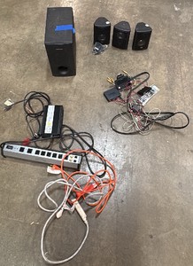 Assortment of speakers, power strips, and miscellaneous wires