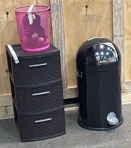 Black plastic storage container, pink wire trash bin, stuffed animal, and black round top trash can