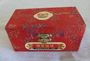 Pair of green Chinese Baoding Exercise and Stress Balls with Floral Bird Design in Red Fabric Presentation Box with Directions.  The Stress Balls make a soft chiming sound when used.