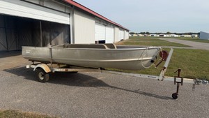 Fishing Boat and trailer with seats that you can store your fishing gear or bait in.