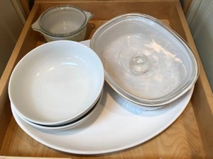 Corning Ware casserole, porcelain bowls, platter, plastic dishes all on 2 shelves